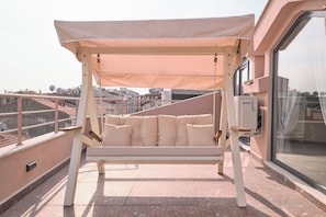 A balcony with a swing seat, a window, and a view of the cityscape. - Carlsen, GOAT, Unique, Full City View Terrace (Kadıköy)