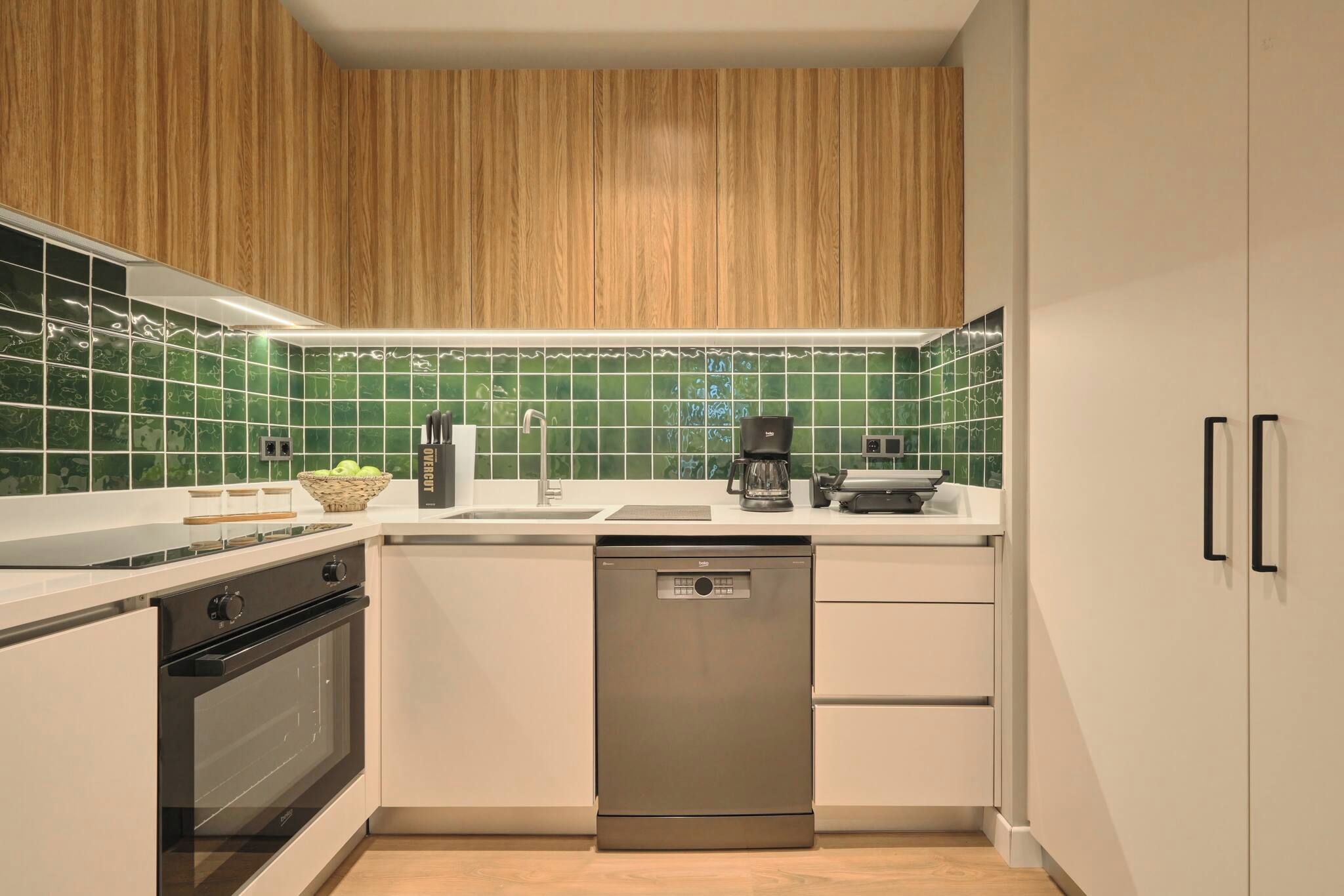 A modern kitchen with wooden cabinets, a dishwasher, and a coffee maker.