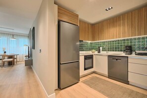 A modern kitchen with a stainless steel refrigerator, wooden cabinets, and a green-tiled backsplash. - Polgar, 3BR, Welcoming, Charming (Kadıköy)