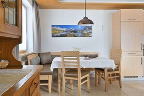 Ein Essbereich mit Tisch, Stühlen und einem Bild an der Wand.
