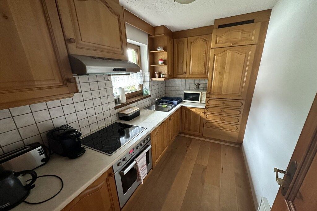 A kitchen with wooden cabinets, a microwave, a stove, and a toaster.