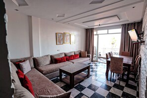 Ein modernes Wohnzimmer mit einer Sofagarnitur, einem Couchtisch und einem Essbereich mit Stühlen und einem Tisch.
