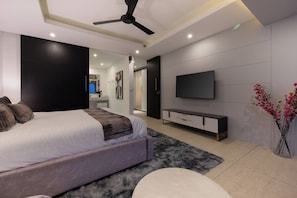 Een moderne slaapkamer met een bed, een flatscreen televisie, een console tafel en een decoratieve vaas.