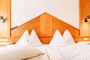 A hotel room with a wooden headboard, white bedding, and bedside lamps. - Apart Zimalis Galtür Ischgl 3-5 Per. (Galtür)