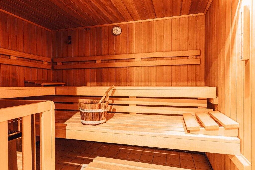 Eine Sauna mit Holzbänken und einem Holzeimer.