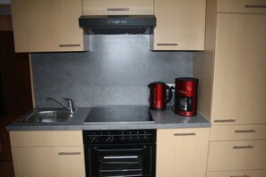 A kitchen with a built-in oven, a coffee maker, and a sink. - Musler on the ground floor (Bad Goisern am Hallstättersee)