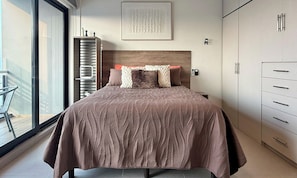 A bedroom with a large bed, a headboard, a wardrobe, a window, and a door. - Premium Loft at a Plaza with restaurants & others (Monterrey)