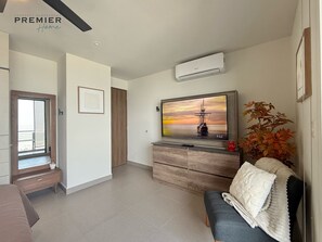 A modern living room with a flat-screen TV, a sofa, a coffee table, and a decorative plant. - Premium Loft at a Plaza with restaurants & others (Monterrey)