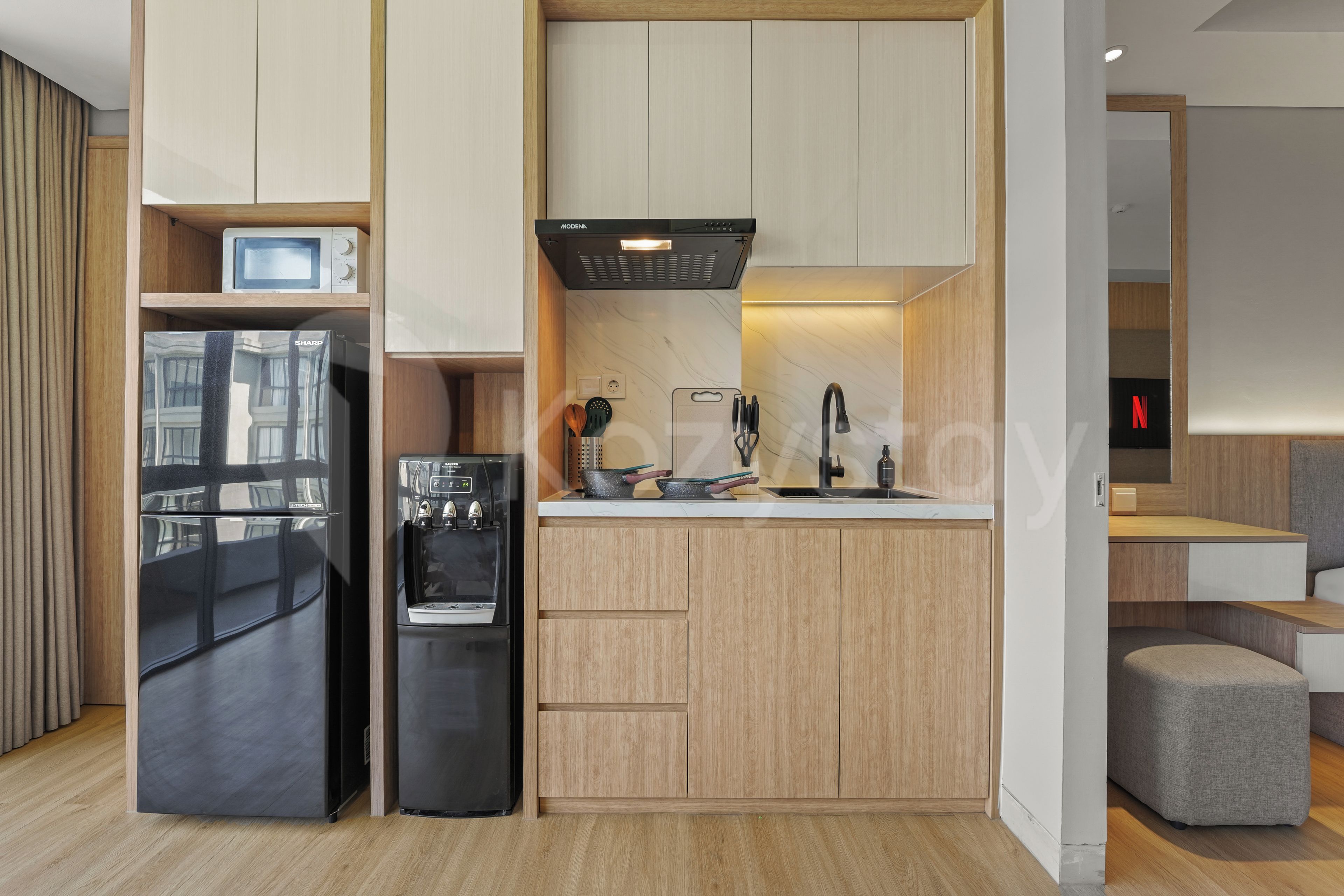 Een moderne keuken met inbouwapparatuur, een houten aanrechtblad en een zithoekje.