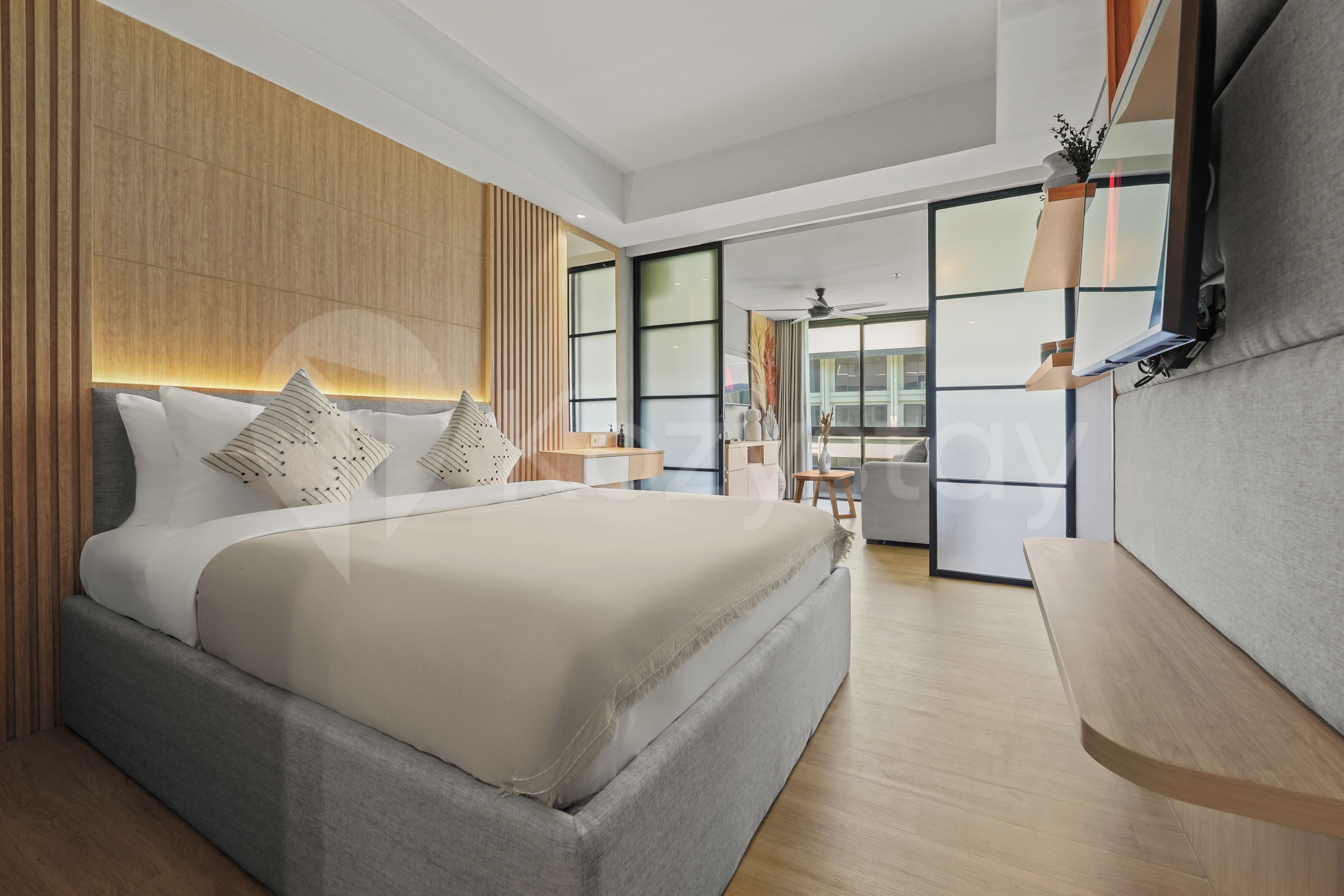 Een moderne slaapkamer met een groot bed, een nachtkastje, een ingebouwde televisie en uitzicht door een glazen deur.