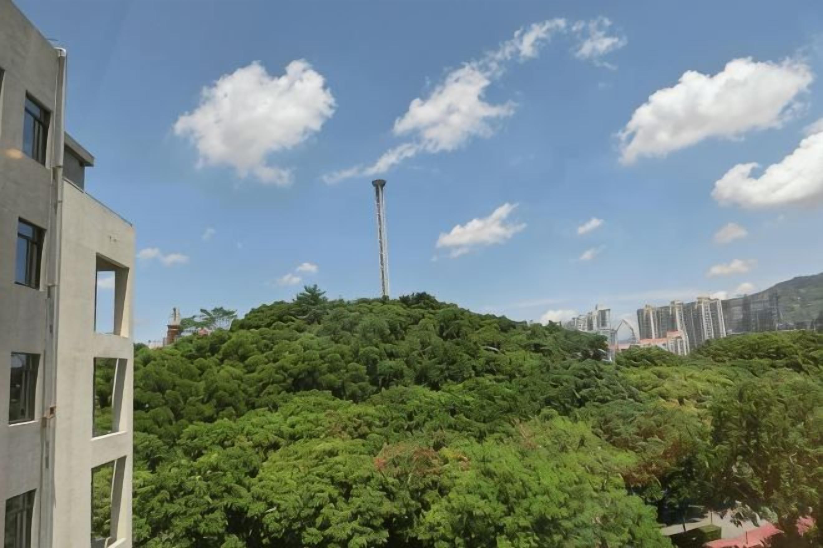 Een gebouw met een modern ontwerp, een heldere lucht en een toren in de verte.