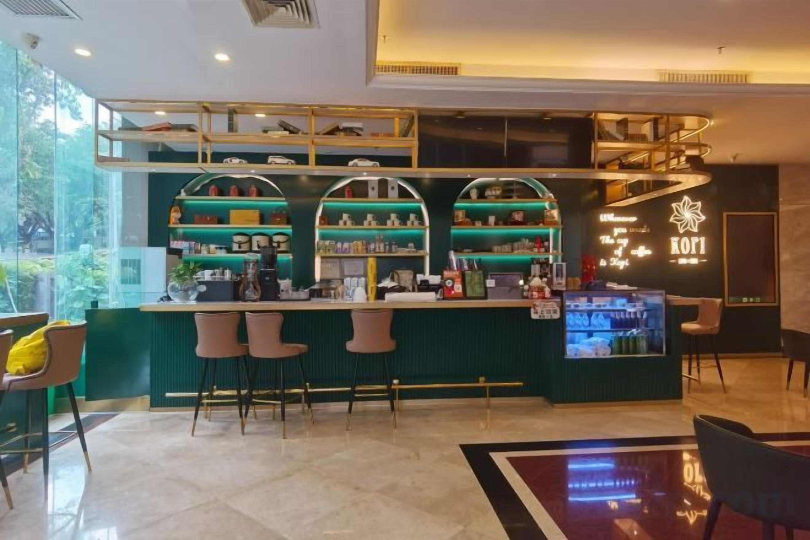 Zona de bar con mostrador, taburetes y estanterías llenas de botellas.