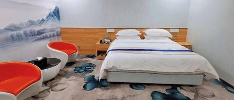 A hotel room with a bed, nightstands, a wall-mounted TV, and a seating area with chairs.