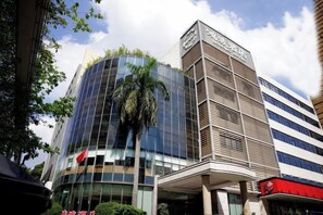 Un edificio moderno con fachada de vidrio curva y estructura de techo plano con líneas horizontales.