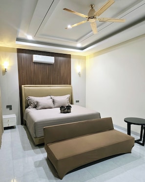 A modern bedroom with a bed, a sofa, a ceiling fan, and an air conditioning unit. - DMranti Villa (Pekan Baru)