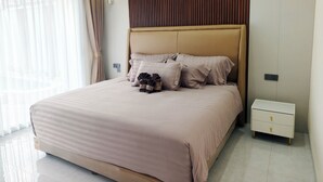 A modern bedroom with a large bed, a nightstand, and an air conditioning unit on the wall. - DMranti Villa (Pekan Baru)