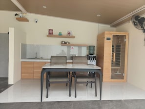 Una cocina moderna con comedor, que incluye una mesa con sillas, dispensador de agua y horno empotrado.