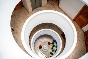 A spiral staircase with a marble floor and a circular design. - Mediterranean Apartment in El Higuerón, Fuengirola – Your Peaceful Oasis (Fuengirola)