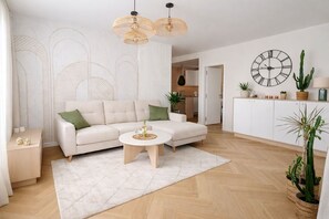A modern living room with a sofa, coffee table, and decorative plants. - Mediterranean Apartment in El Higuerón, Fuengirola – Your Peaceful Oasis (Fuengirola)