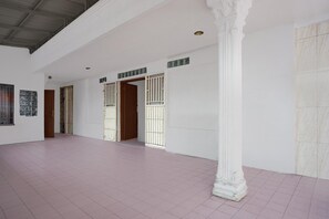 A spacious corridor with white walls, a tiled floor, and a large white column. - Luxury Deluxe DBL Retreat W/ Free WiFi and Parking (Medan)