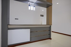 A reception desk with a white panel, three pendant lights, and a small window. - Luxury Deluxe DBL Retreat W/ Free WiFi and Parking (Medan)