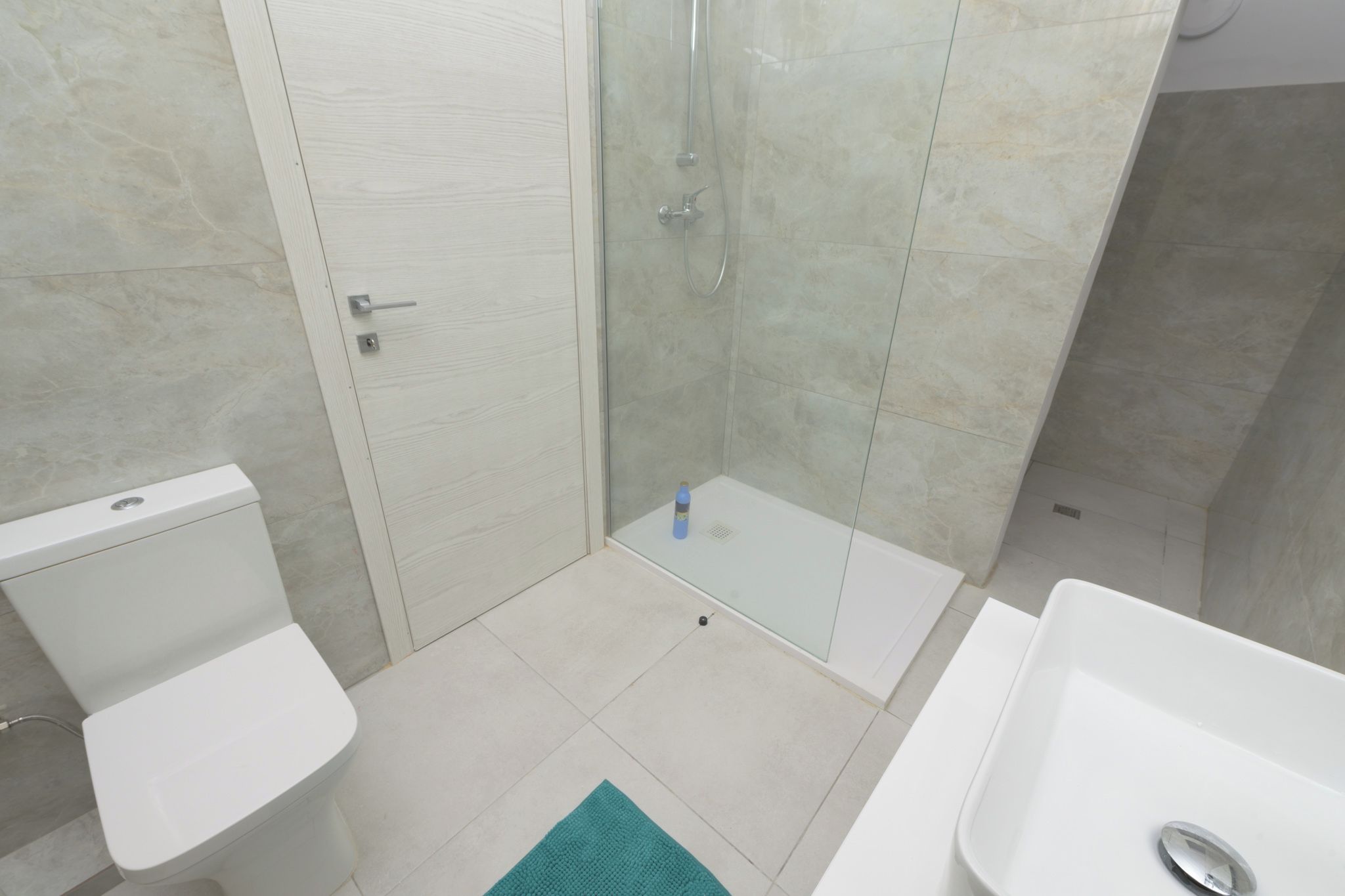 Ein Badezimmer mit Toilette, Duschkabine und Waschbecken.