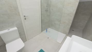 Un bagno con un WC, un box doccia e un lavandino.
