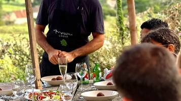 Une personne servant des plats à une table en plein air, avec une vue panoramique.