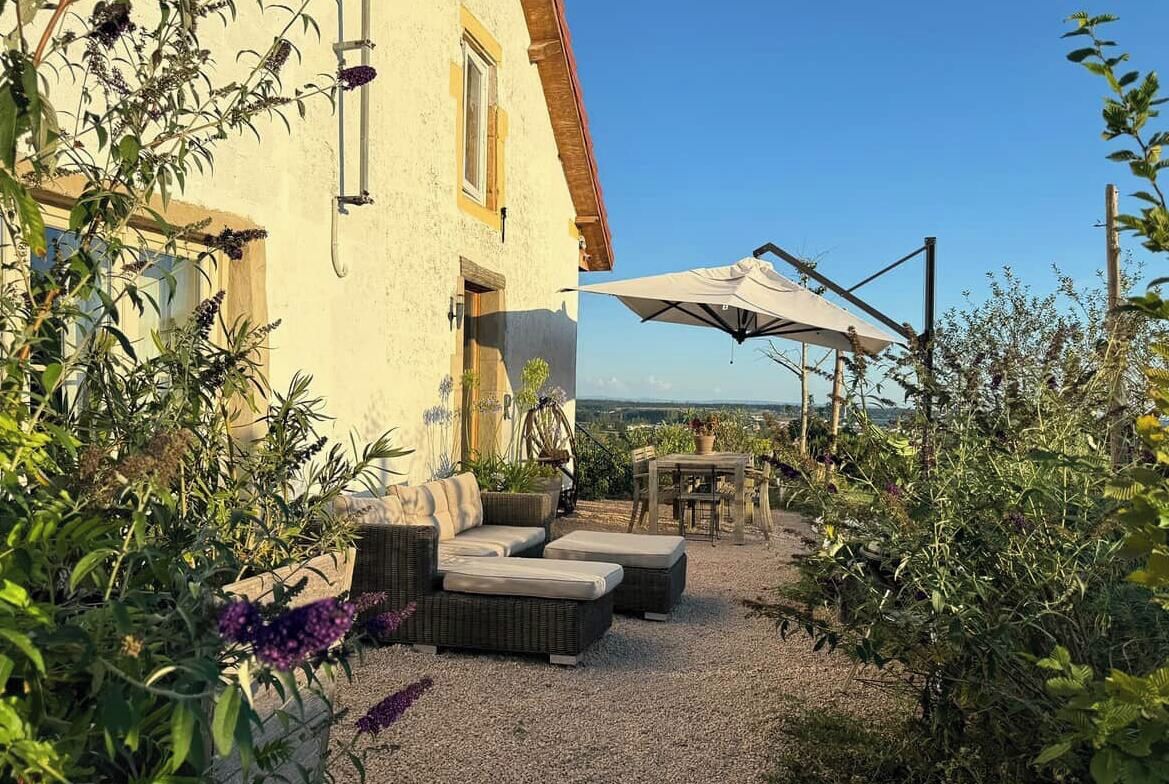 Un bâtiment doté d’un patio aménagé avec du mobilier d’extérieur et une table.
