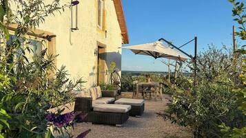 Un bâtiment doté d’un patio aménagé avec du mobilier d’extérieur et une table.