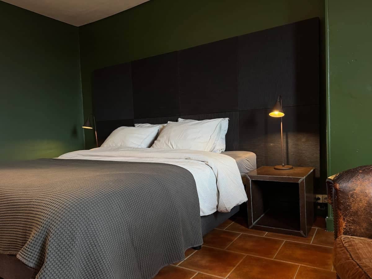Une chambre à coucher avec un lit, une table de chevet, une lampe et une chaise.
