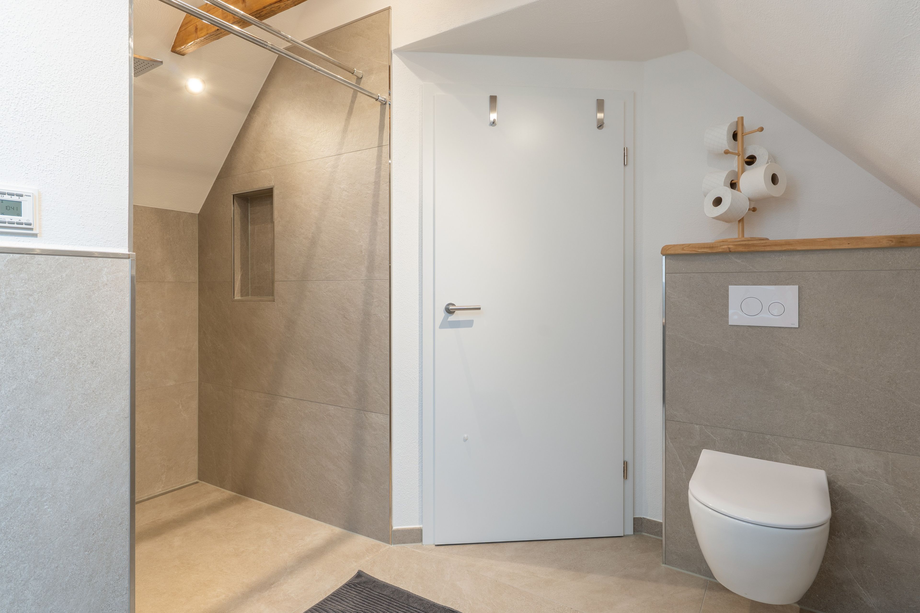Ein Badezimmer mit Dusche, Toilette und Handtuchhalter.