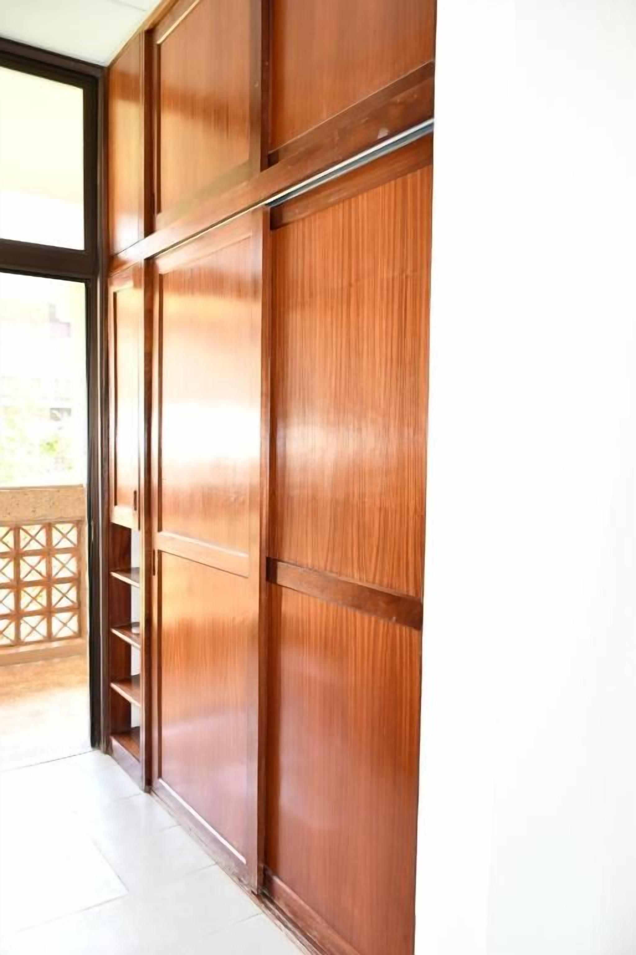 Una puerta corredera de madera que da a un balcón con celosía.