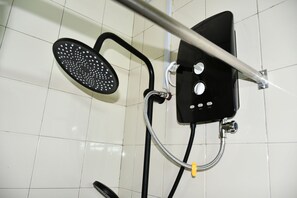 A shower with a handheld showerhead, a wall-mounted control panel, and a handheld scrubber. - AICAD Guest House (Juja)