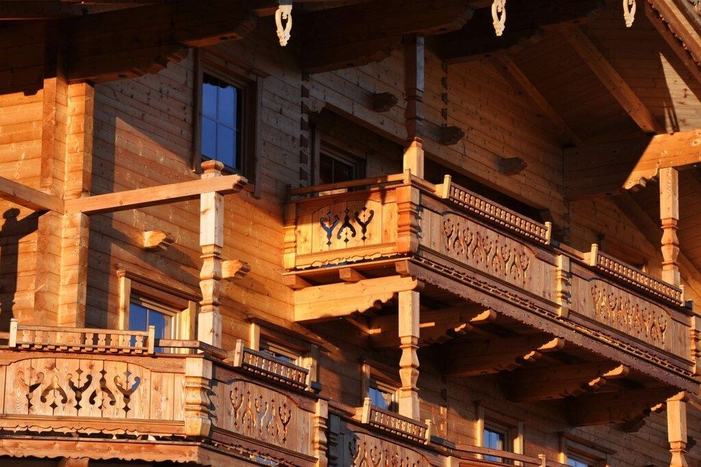 A multi-story building with intricate wooden balconies and a traditional architectural style.