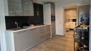 A modern kitchen with a central island, built-in appliances, and a dining area with a sofa. - Vrbo Property (Allstedt)