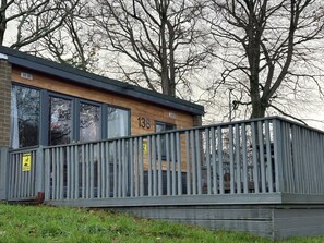 Een gebouw met een houten gevel, nummer 138, met grote ramen en een balkon met een metalen hekwerk.