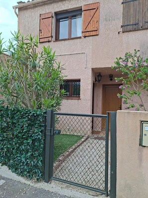 A building with a gated entrance, a wooden door, and a small window with shutters. - Small house 2 km from the sea (villeneuve-Loubet)