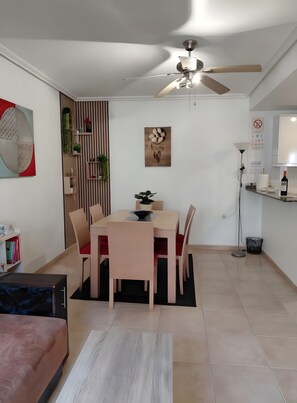 A modern dining area with a table and chairs, a ceiling fan, and a wall-mounted artwork. - Bungalow ', La Veleta' with Mountain View, Shared Pool and Wi-Fi (Torrevieja)