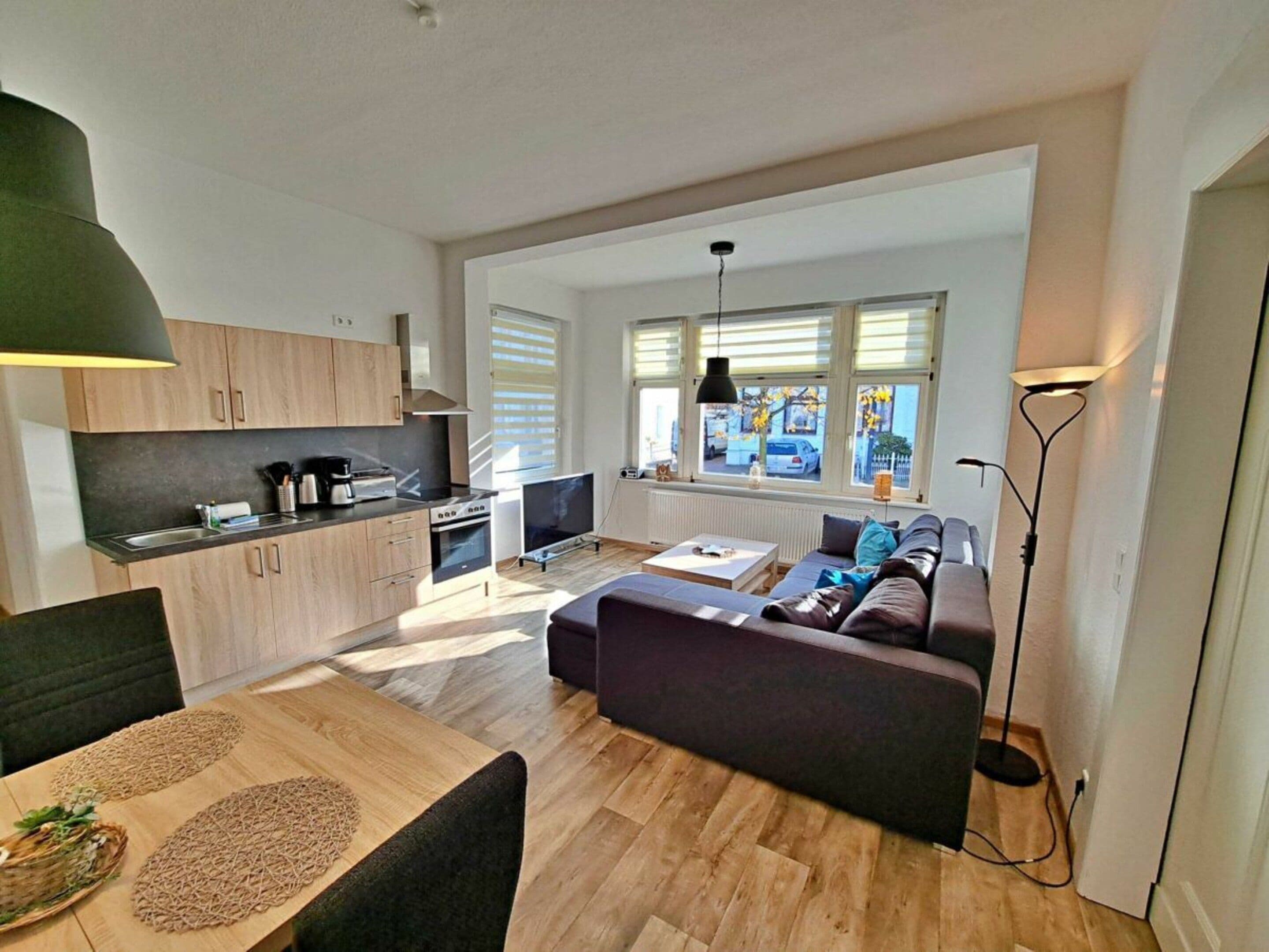 A modern apartment with a kitchen, dining area, and living room.
