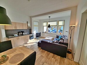 Een modern appartement met keuken, eethoek en woonkamer.