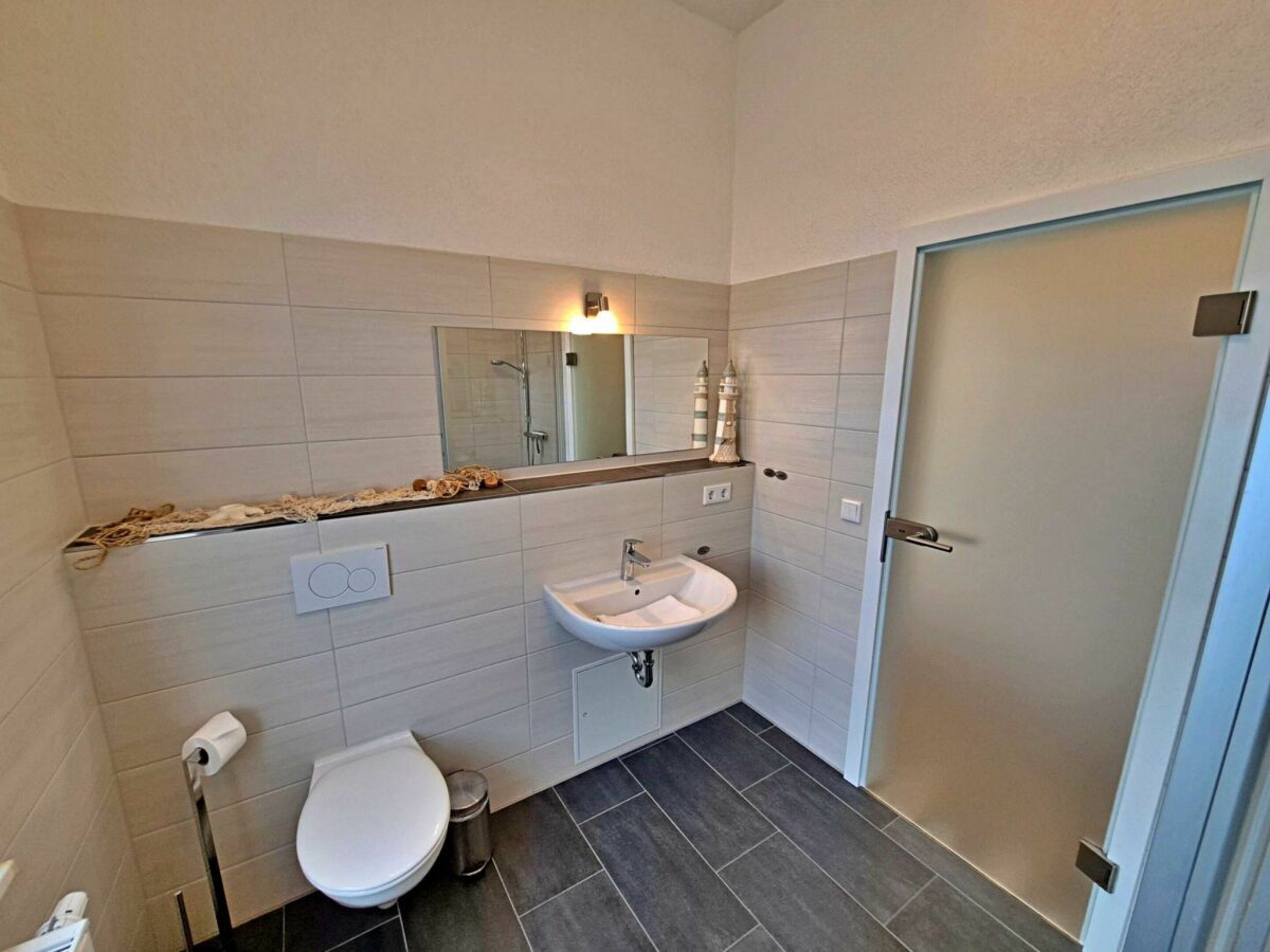 Een badkamer met toilet, wastafel en douche.