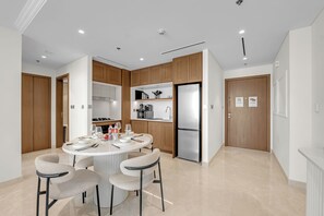 Una cocina moderna con una isla central, electrodomésticos integrados y una zona de comedor con cuatro sillas.