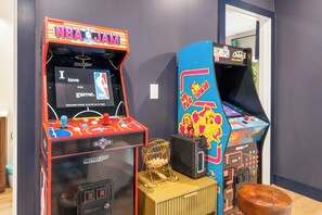 Zwei Spielautomaten mit NBA-Logos, ein goldener Pokal und ein brauner Ledersitz.