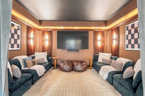 Ein modernes Wohnzimmer mit zwei Sofas, einem großen Flachbildfernseher und einem gemusterten Teppich.
