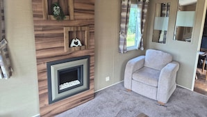 A living room with a fireplace, a sofa, and a wall-mounted mirror.