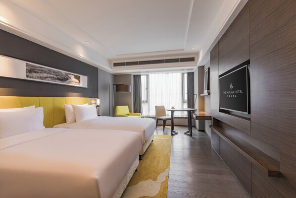 A hotel room with two beds, a desk, a chair, a television, and a large window. - The Mulian Hotel (Chengdu)