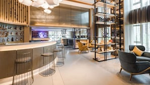 A modern interior with a bar area, seating, and bookshelves. - The Mulian Hotel (Chengdu)
