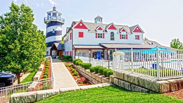 A waterfront hotel with a lighthouse, a pool, and a covered patio. - A Charming Lakeside Escape with Endless Family Fun- Branson Family Fun-3 Bd. (Branson)