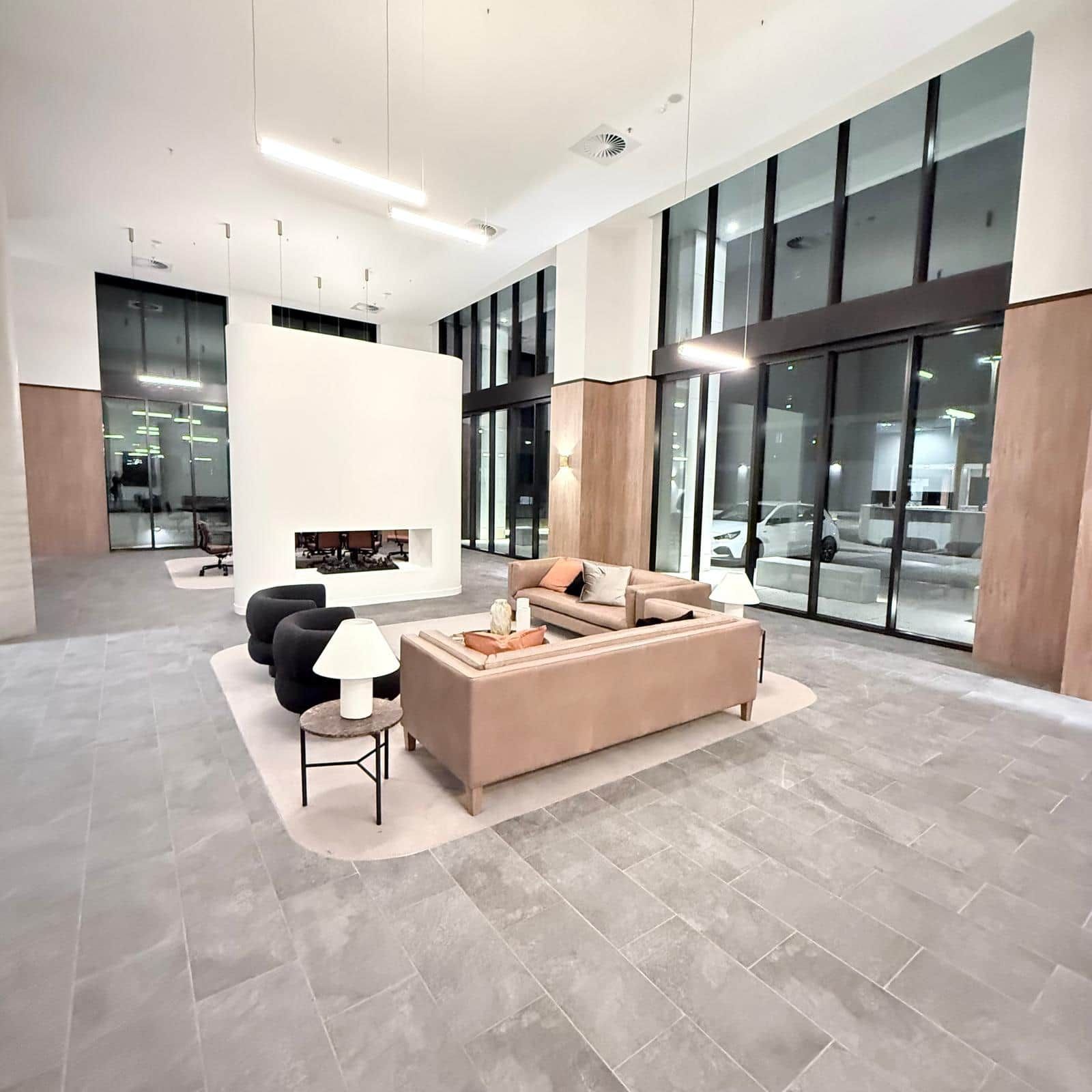 A spacious lobby with a modern sofa, a coffee table, and a fireplace.